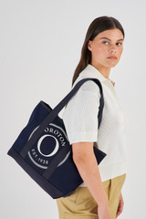 Profile view of model wearing the Oroton Kane Small Shopper Tote in Navy and Recycled Canvas for Women