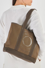 Profile view of model wearing the Oroton Kane Small Shopper Tote in Khaki and Recycled Canvas for Women