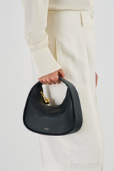 Profile view of model wearing the Oroton Clara Mini Bag in Black and Pebble leather for Women