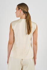 Profile view of model wearing the Oroton Fluid Satin Shell Top in Vanilla Bean and 80% Acetate, 20% Polyester for Women