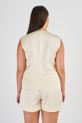 Profile view of model wearing the Oroton Fluid Satin Shell Top in Vanilla Bean and 80% Acetate, 20% Polyester for Women