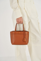 Profile view of model wearing the Oroton Harvey Small Tote in Cognac and Smooth leather for Women