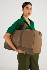 Profile view of model wearing the Oroton Kane Weekender in Khaki and  for Women