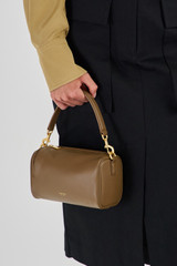 Profile view of model wearing the Oroton Thea Small Barrel Bag in Willow and Smooth Leather for Women