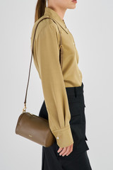 Profile view of model wearing the Oroton Thea Small Barrel Bag in Willow and Smooth Leather for Women