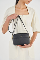 Profile view of model wearing the Oroton Harvey Camera Crossbody in Black and Smooth Leather for Women