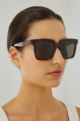 Profile view of model wearing the Oroton Sunglasses Easton in Signature Tort and Acetate for Women