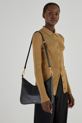 Profile view of model wearing the Oroton North Hobo in Black and Smooth Leather for Women