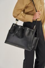 Profile view of model wearing the Oroton Harvey Baby Bag And Mat in Black and Smooth Leather for Women