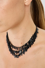 Profile view of model wearing the Oroton Vera Necklace in Black and Brass for Women