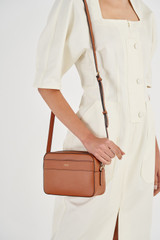 Profile view of model wearing the Oroton Harvey Camera Crossbody in Cognac and Smooth Leather for Women