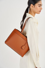 Profile view of model wearing the Oroton Harvey Medium Tote in Cognac and Smooth Leather for Women