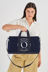 Profile view of model wearing the Oroton Kane Carry All in Navy and Recycled Canvas for Women