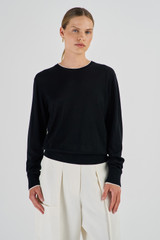 Profile view of model wearing the Oroton Contrast Trim Crew Neck in Black and 100% Merino Wool for Women