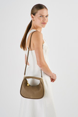 Profile view of model wearing the Oroton Clara Mini Bag in Willow and Pebble Leather for Women