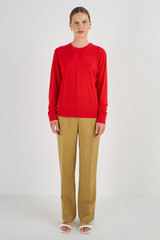 Profile view of model wearing the Oroton Contrast Trim Crew Neck in Poppy and 100% Merino Wool for Women