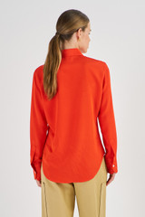Profile view of model wearing the Oroton Slim Fit Silk Shirt in Poppy and 93% Silk 7% Spandex for Women