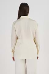 Profile view of model wearing the Oroton Slim Fit Silk Shirt in Vanilla Bean and 93% Silk 7% Spandex for Women