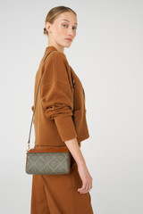 Profile view of model wearing the Oroton Harvey Signature Baguette Crossbody in Black/Cognac and Printed Coated Canvas With Leather Trims for Women