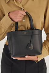 Profile view of model wearing the Oroton Harvey Small Tote in Black and Smooth leather for Women