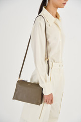 Profile view of model wearing the Oroton Sadie Crossbody in Olive and Pebble Leather for Women