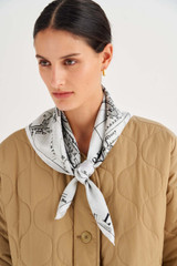 Profile view of model wearing the Oroton Map Scarf in Antique Cream and 100% Silk for Women