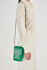 Profile view of model wearing the Oroton Harriet Phone Crossbody in Emerald and Saffiano Leather for Women
