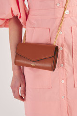 Profile view of model wearing the Oroton Bella Clutch Wallet in Cognac II and Soft Saffiano for Women