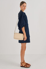 Profile view of model wearing the Oroton Polly Crossbody in Oatmeal and Pebble Leather for Women