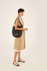 Profile view of model wearing the Oroton Lyla Hobo in Black and Pebble Leather for Women
