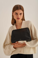 Profile view of model wearing the Oroton Nova Day Bag in Black and Smooth Leather for Women