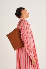 Profile view of model wearing the Oroton Lyla Day Bag in Cognac and Pebble Leather and Smooth Leather for Women