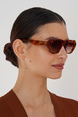Profile view of model wearing the Oroton Quade Sunglasses in Amber Tort and Acetate for Women