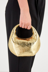 Profile view of model wearing the Oroton Tulip Metallic Mini Day Bag in Gold and Pebble Leather for Women