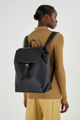 Profile view of model wearing the Oroton Margot Large Backpack in Black and Pebble Leather for Women