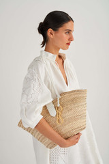 Profile view of model wearing the Oroton Madison Medium Tote in White/Natural and Smooth Leather and Woven Straw for Women