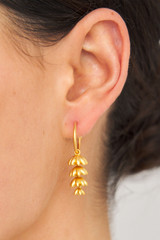Profile view of model wearing the Oroton Riley Drop Hoops in Worn Gold and Brass Base With 18CT Gold Plating for Women