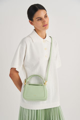 Profile view of model wearing the Oroton Reed Small Day Bag in Herb Garden and Pebble Leather for Women