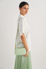 Profile view of model wearing the Oroton Reed Small Day Bag in Herb Garden and Pebble Leather for Women