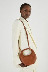 Profile view of model wearing the Oroton Tulip Mini Day Bag in Milk Chocolate and Pebble Leather for Women
