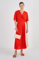 Profile view of model wearing the Oroton Colour Block Pleat Dress in True Red and 100% Polyester for Women