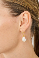 Profile view of model wearing the Oroton Marlee Drop Earrings in Worn Gold/White and 18-karat gold plating for Women