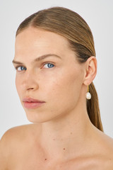 Profile view of model wearing the Oroton Marlee Drop Earrings in Worn Gold/White and 18-karat gold plating for Women