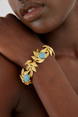 Profile view of model wearing the Oroton Tropea Bracelet in Worn Gold/Turquoise and 18-karat gold plating for Women