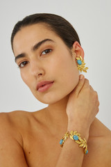 Profile view of model wearing the Oroton Tropea Clip On Earrings in Worn Gold/Turquoise and 18-karat gold plating for Women