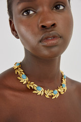 Profile view of model wearing the Oroton Tropea Necklace in Worn Gold/Turquoise and Brass for Women
