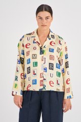 Profile view of model wearing the Oroton Alphabet Print Camp Shirt in Jute and 100% Silk for Women