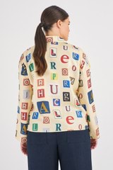 Profile view of model wearing the Oroton Alphabet Print Camp Shirt in Jute and 100% Silk for Women