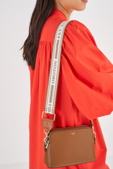 Profile view of model wearing the Oroton Heather Webbing Strap in Cognac/Natural and  for Women