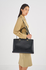 Profile view of model wearing the Oroton Anika Texture 13" Day Bag in Black Croc and Embossed Croc Leather for Women